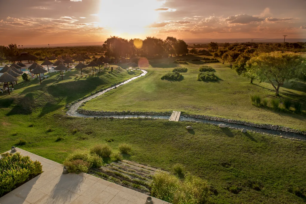 El parque del hotel con el arroyo y el sol bajo
