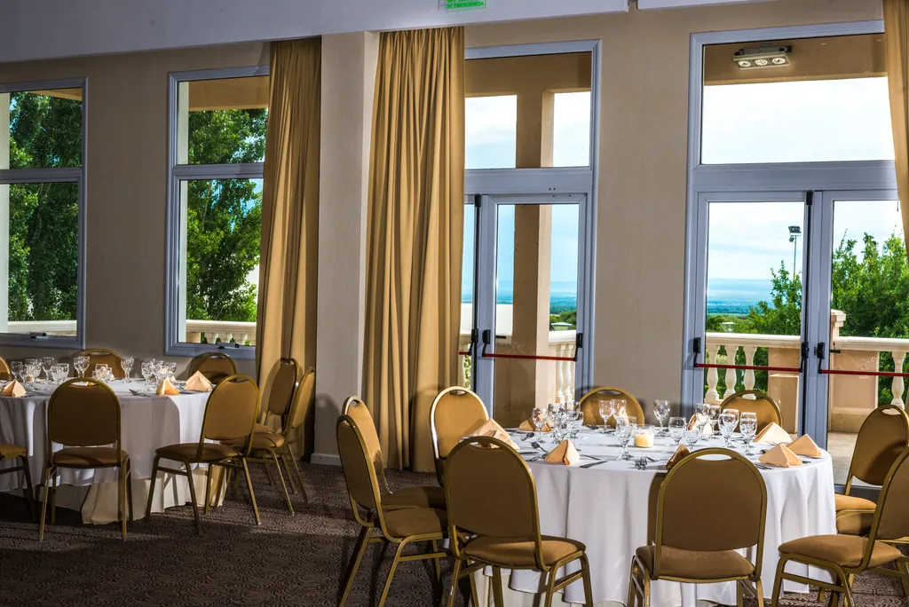 Salón con mesas redondas y ventanales